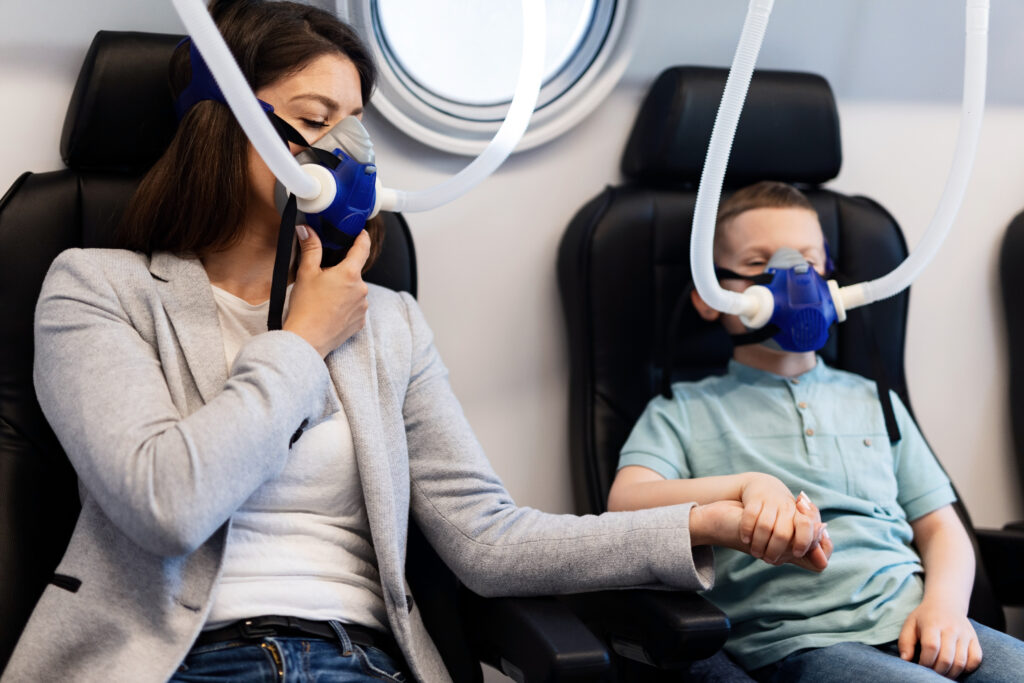 Une femme et un petit garçon respirant à travers un masque à oxygène
